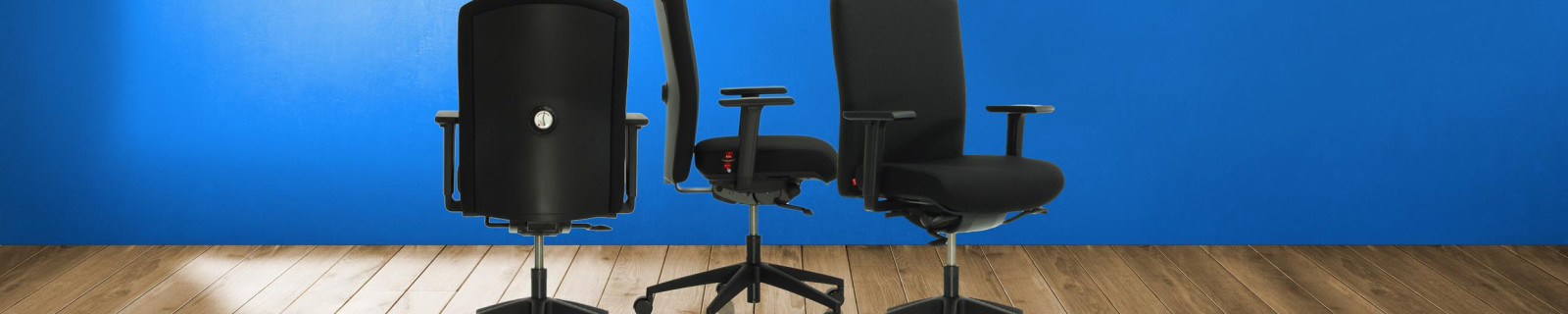 Drei schwarze Bürostühle auf einem Holzfußboden vor einer blauen Wand.