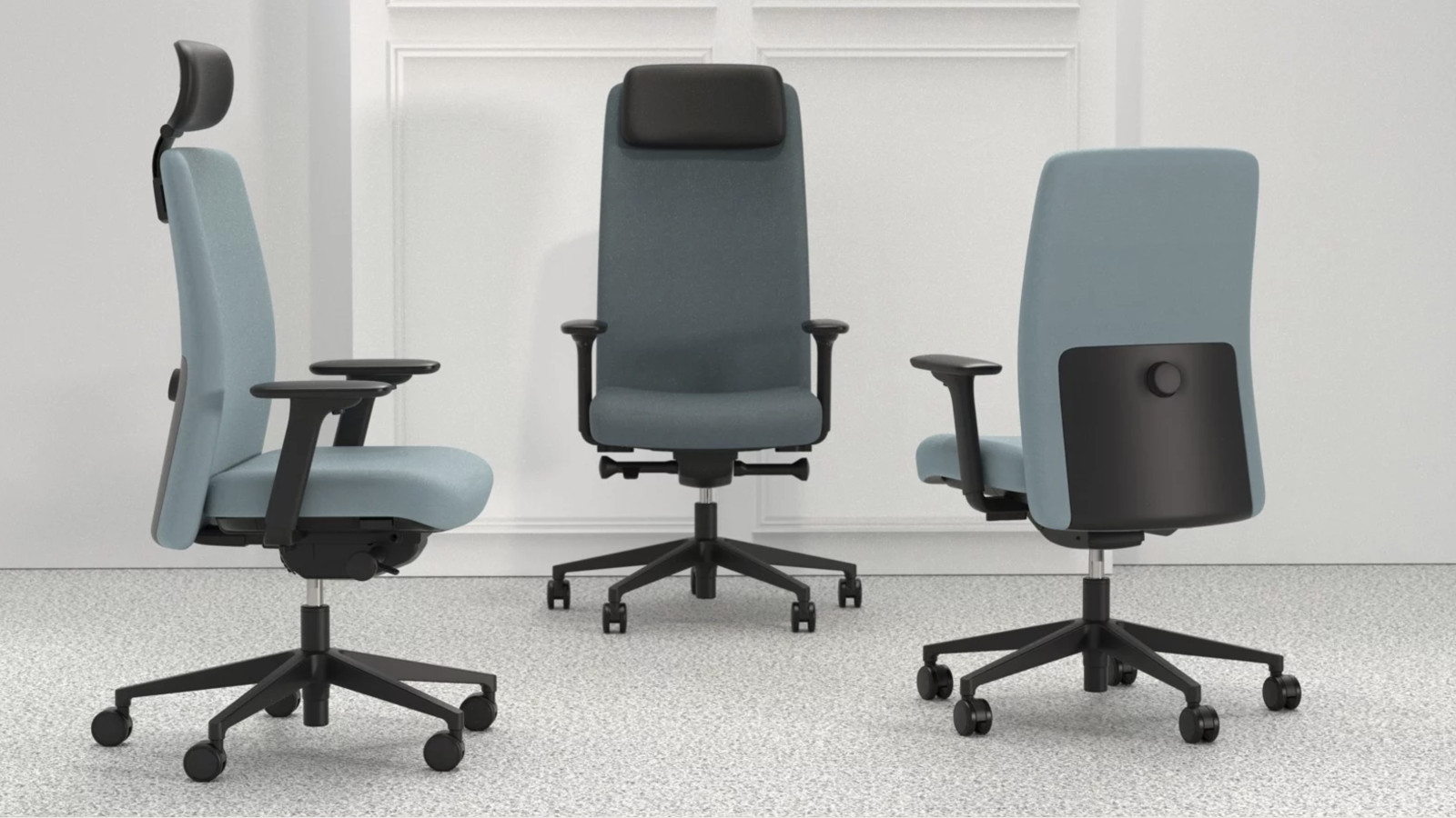 Drei ergonomische Bürostühle in Grau mit verstellbarer Rückenlehne auf hellem Teppichboden.