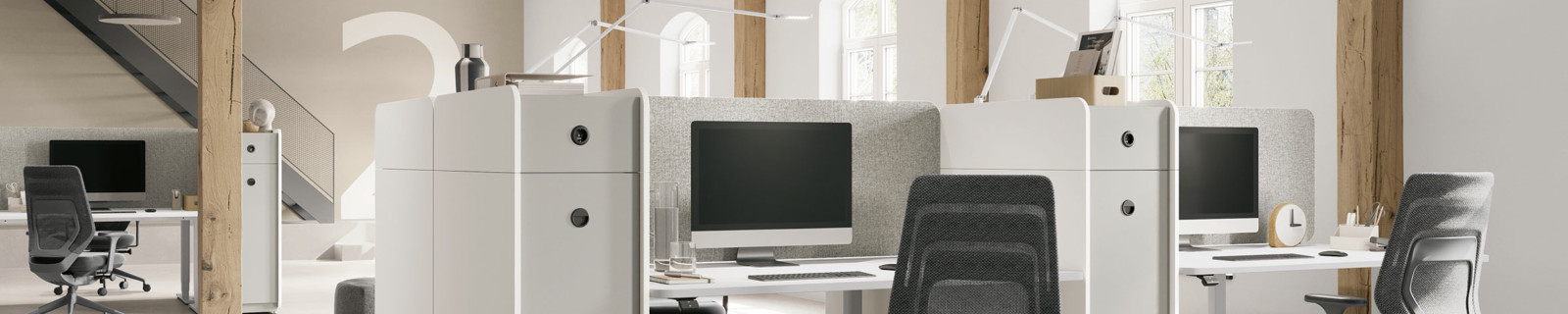 Offenes Büro mit Schreibtischen, Stühlen und Holzträgern in einem hellen Raum.
