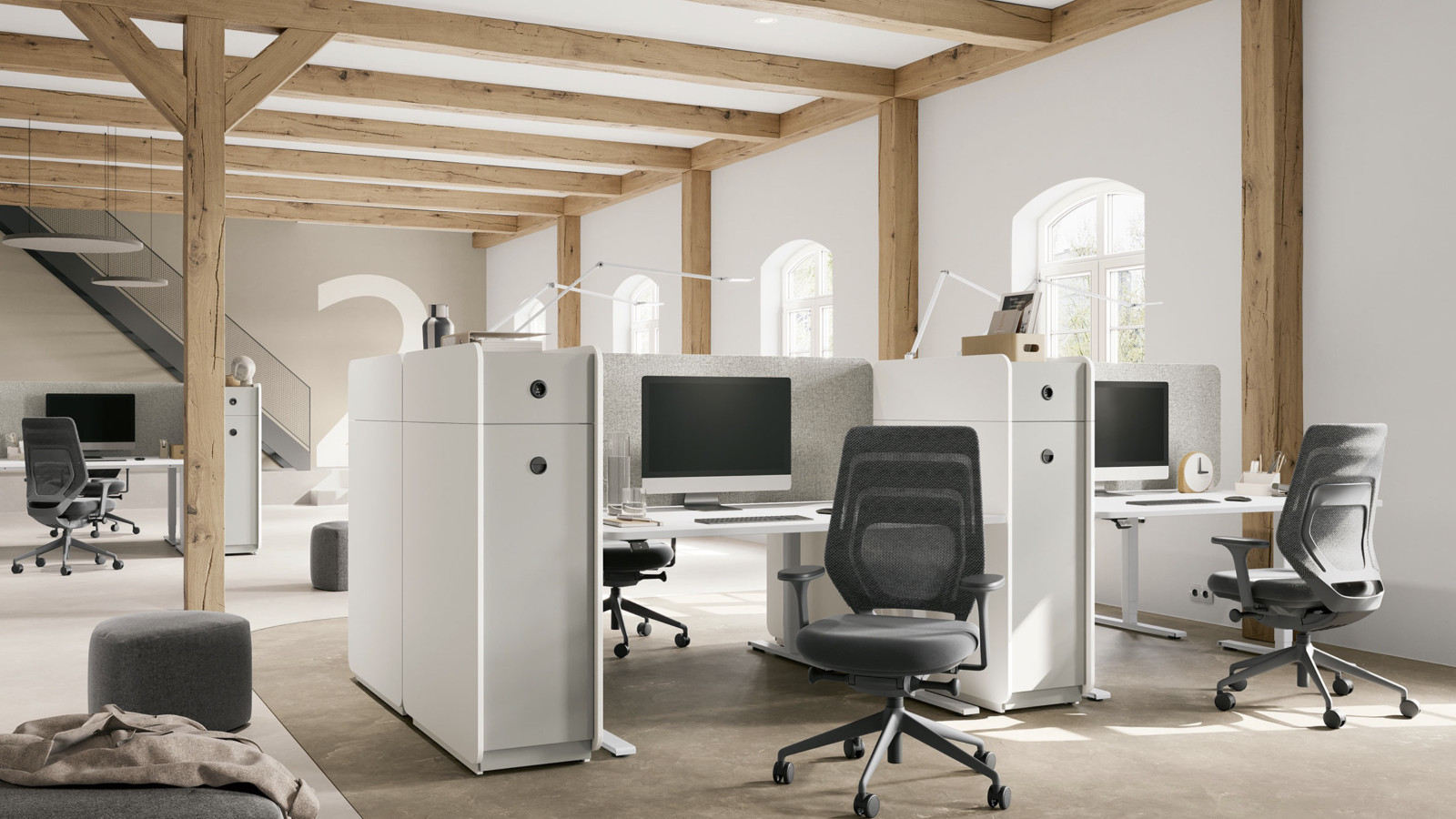 Ein modernes Büro mit offenen Arbeitsplätzen, ergonomischen Stühlen und Computern.