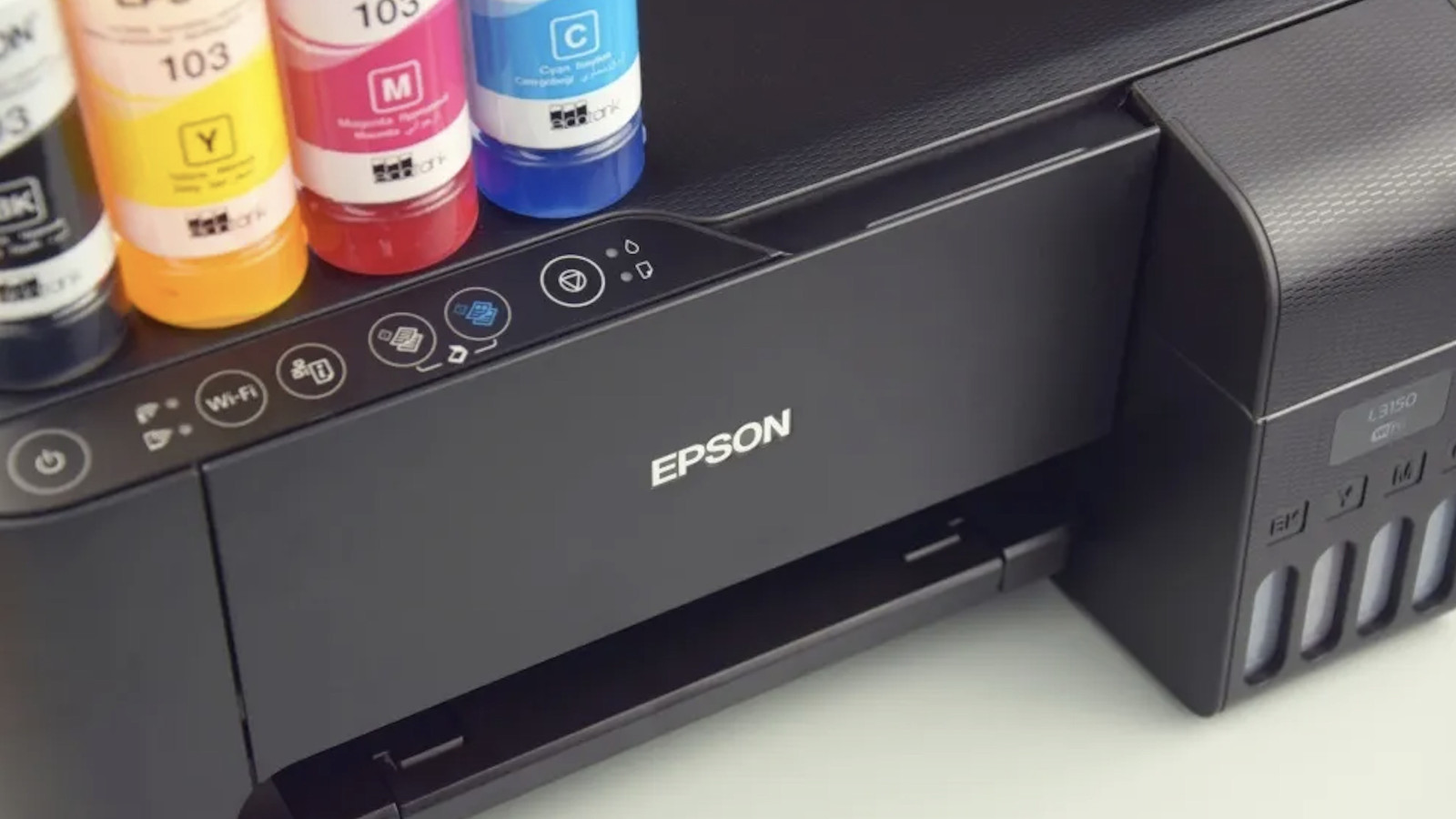 Ein Epson Drucker mit gelben, magentafarbenen und blauen Tintenflaschen daneben.