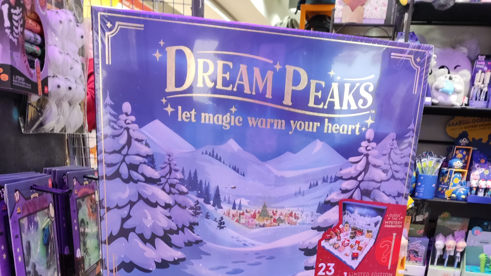 Dream Peaks Adventskalender mit verschneiter Landschaft und Aufschrift im Geschäft.